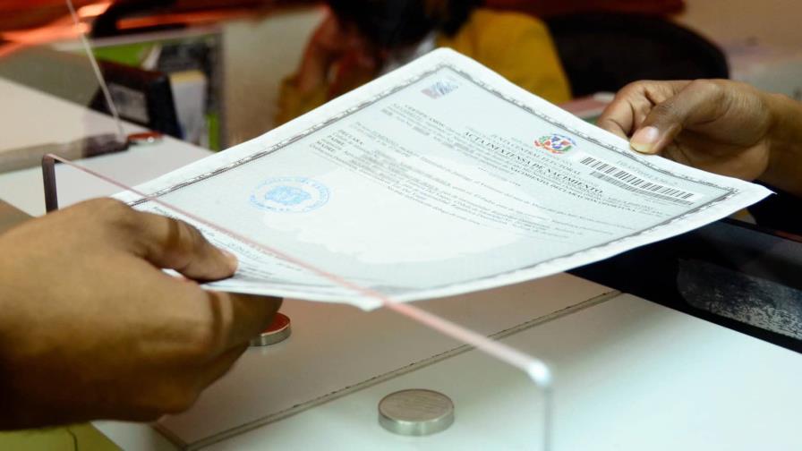 A Dominican Acta Inextensa in the JCE unified civil-document format, shown at a Civil Registry office in the Dominican Republic